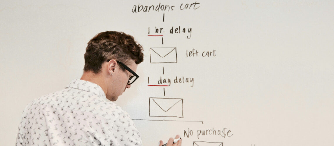 a man writing a workflow on a white board