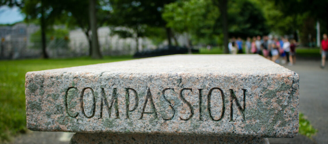 a park bench with the word "compassion" engraved into it