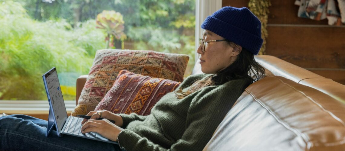 woman working on laptop on couch